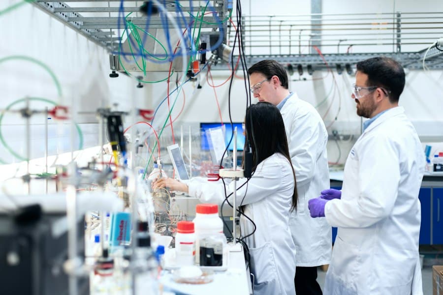 Researchers in lab coats and safety glasses working at a laboratory bench